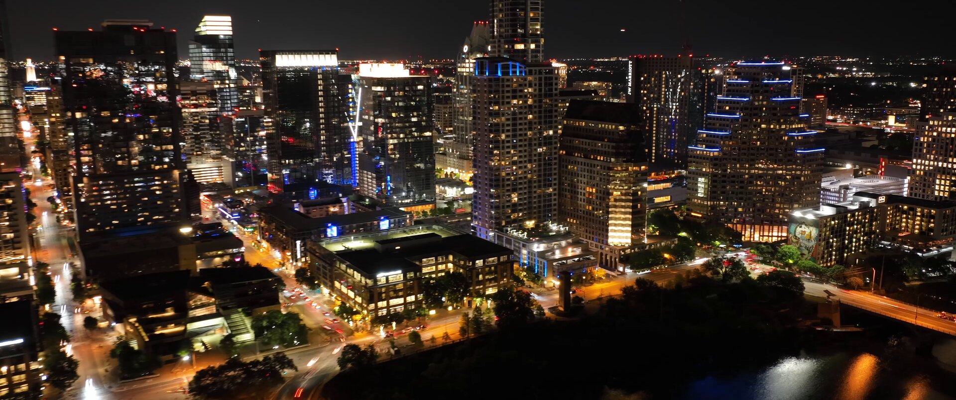 Downtown Austin skyline at night over Lady Bird Lake — frame from the Woodson reel