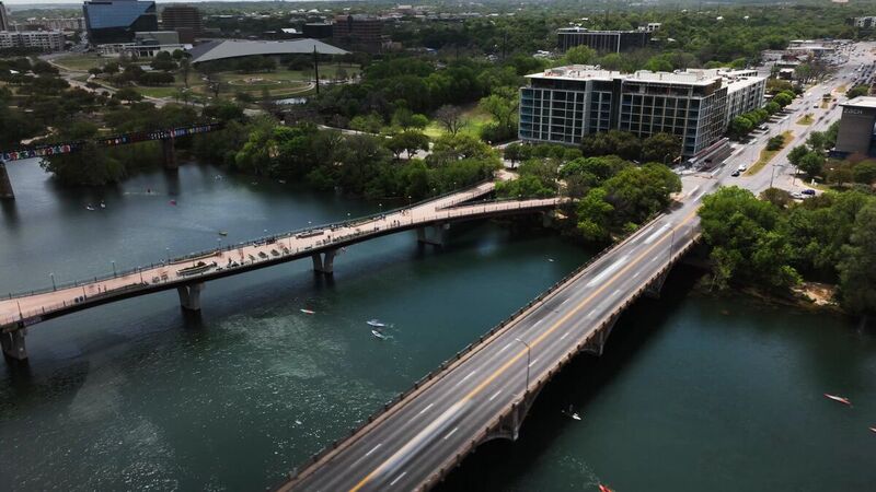 Aerial of the pedestrian bridge and paddlers on Lady Bird Lake, Austin